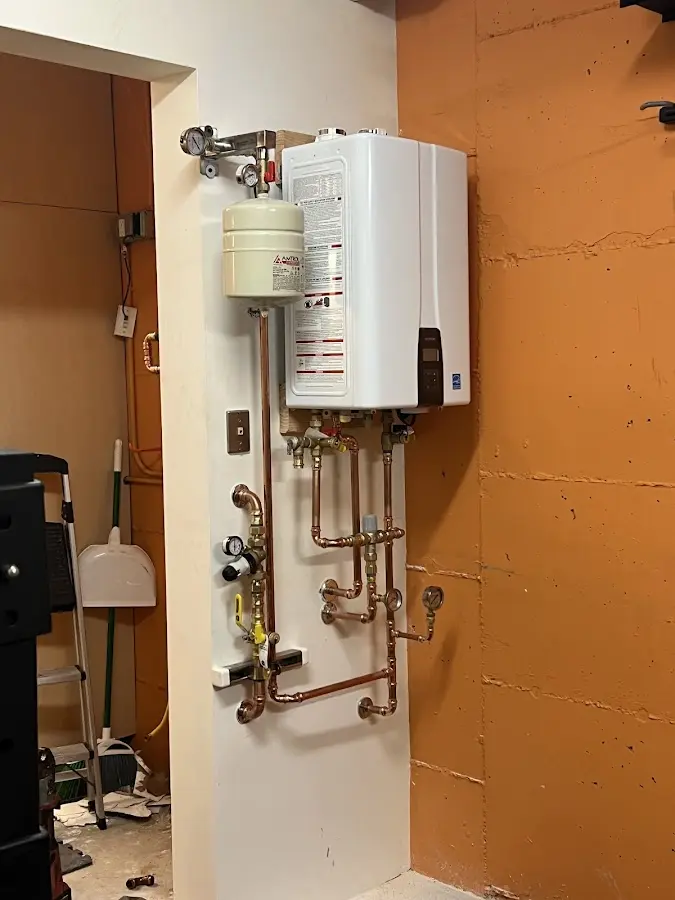 Plumbing technician inspecting water heater connections in Bothell East